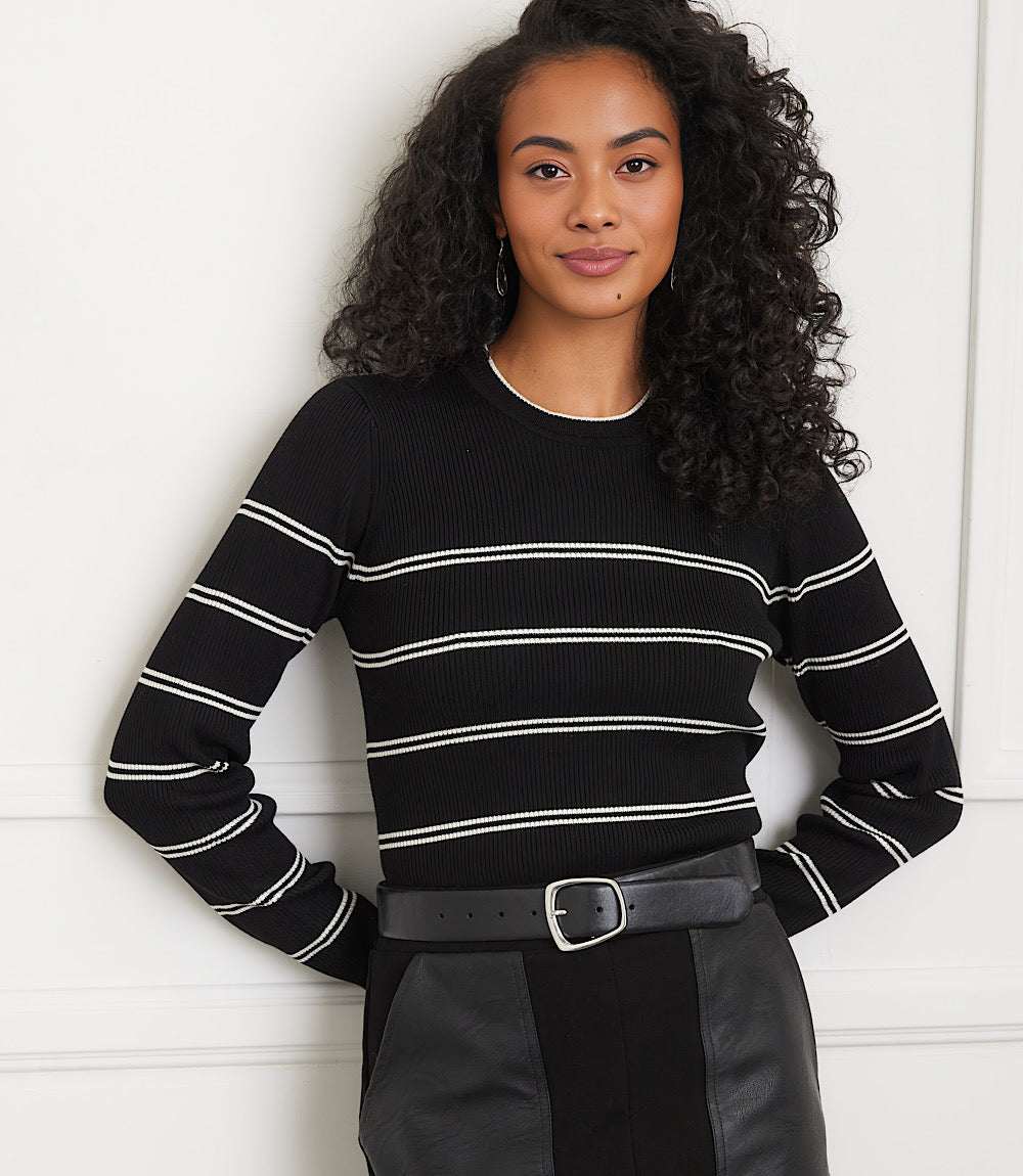Woman wearing a slim-fit black double stripe ribbed sweater with cream stripes and crew neckline