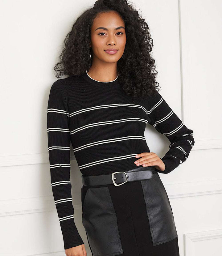 Woman wearing a slim-fit black double stripe ribbed sweater with cream stripes and crew neck, styled with black belt and skirt.