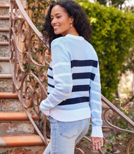 Light blue stripe crewneck sweater with navy and off white stripes worn by woman outdoors