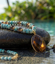 Gemstone pendant necklace with turquoise beads and gold-plated brass setting