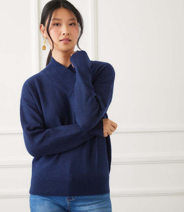 Navy blue shawl collar sweater with drop shoulders and ribbed cuffs modeled by a woman