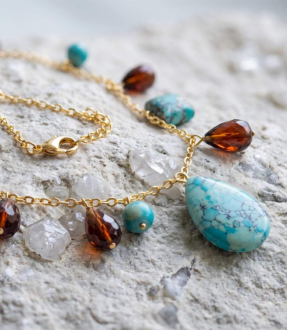 Dangling turquoise and gemstone necklace with gold-tone chain and teardrop pendant