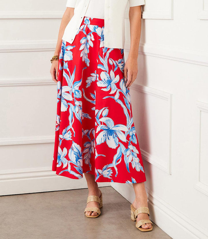 Red midi circle skirt with blue and white floral print, flowing full silhouette, and side zipper closure