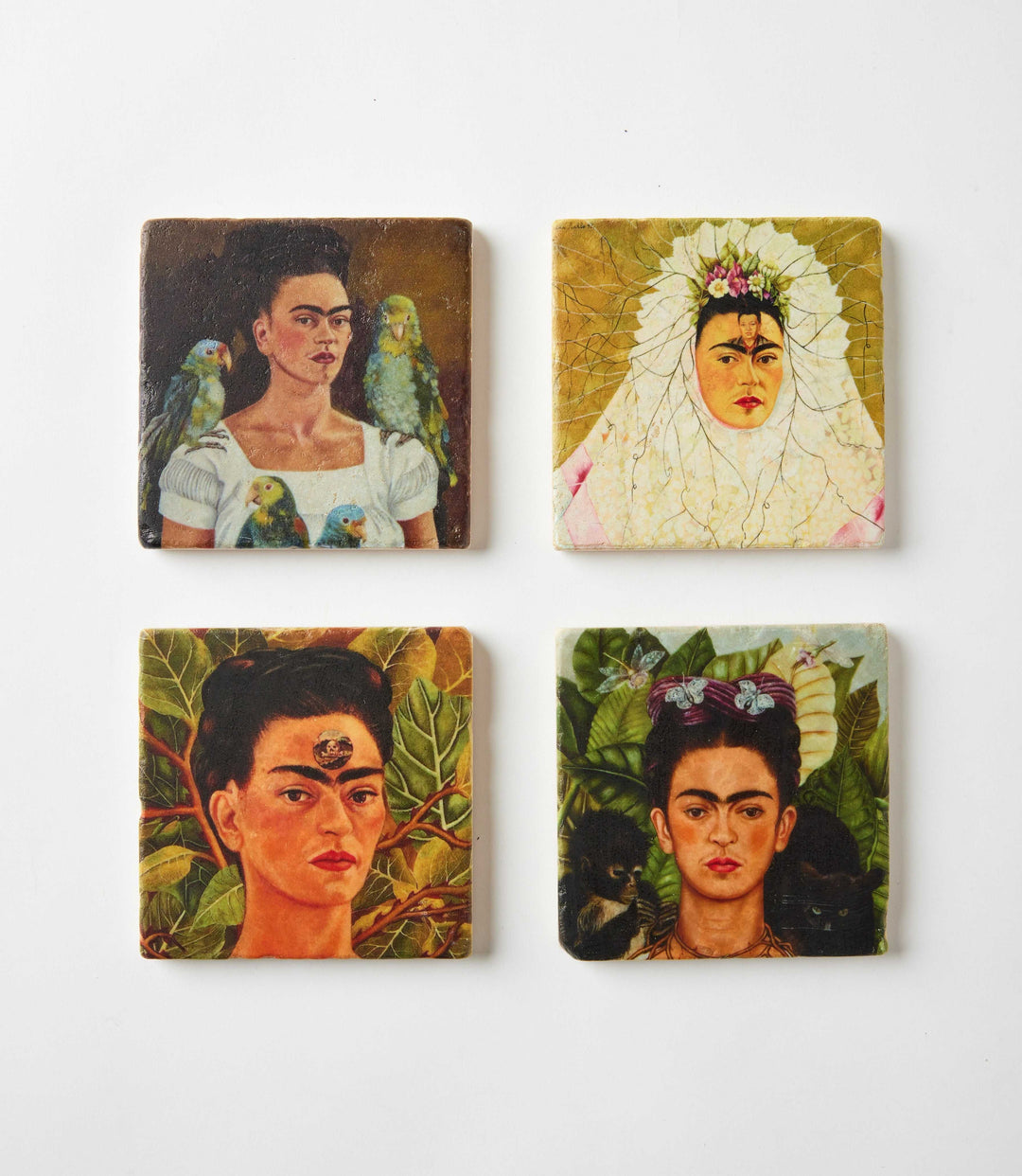 Set of four square Frida Kahlo marble coasters featuring vivid portraits on tumbled marble.
