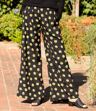 Wide-leg pants with black and yellow floral print, elastic waistband, and side pockets in butter-print woven fabric