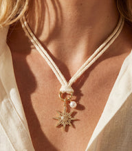 Pavé Burst and Pearl Cord Necklace with cotton cord, cubic zirconia starburst charm, freshwater pearl, and gold plating