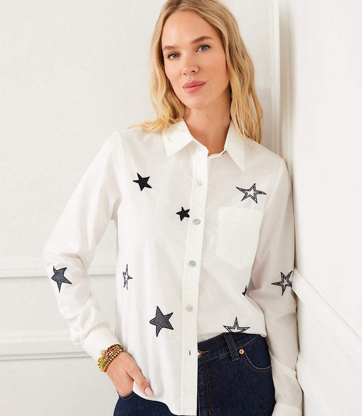 Woman wearing long sleeve embroidered star shirt with navy blue stars on off white cotton poplin fabric
