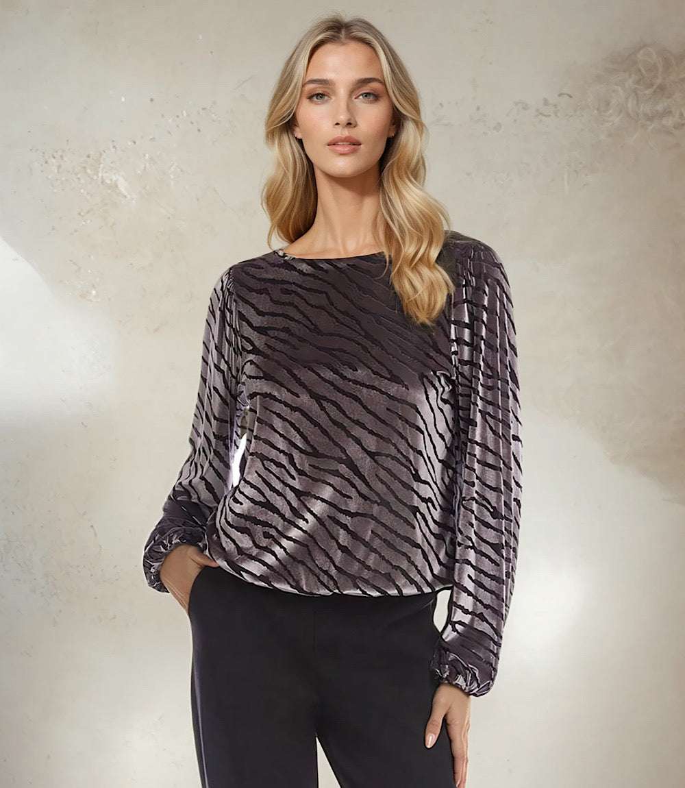 Woman wearing black and silver blouson sleeve velvet burnout top with boatneck and elastic cuffs