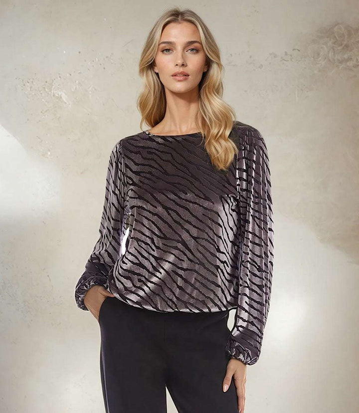 Woman wearing black and silver blouson sleeve velvet burnout top with boatneck and elastic cuffs