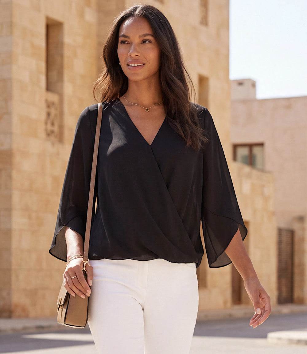Woman wearing bracelet sleeve drape front crossover top with flare sleeves and V-neck