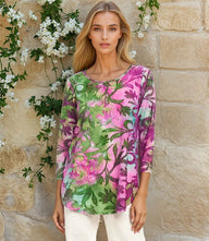 Woman wearing pink and green floral 3/4 sleeve burnout shirttail top with scoop neck and relaxed fit