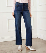 Woman wearing full length wide leg jeans in dark stretch denim with zipper closure