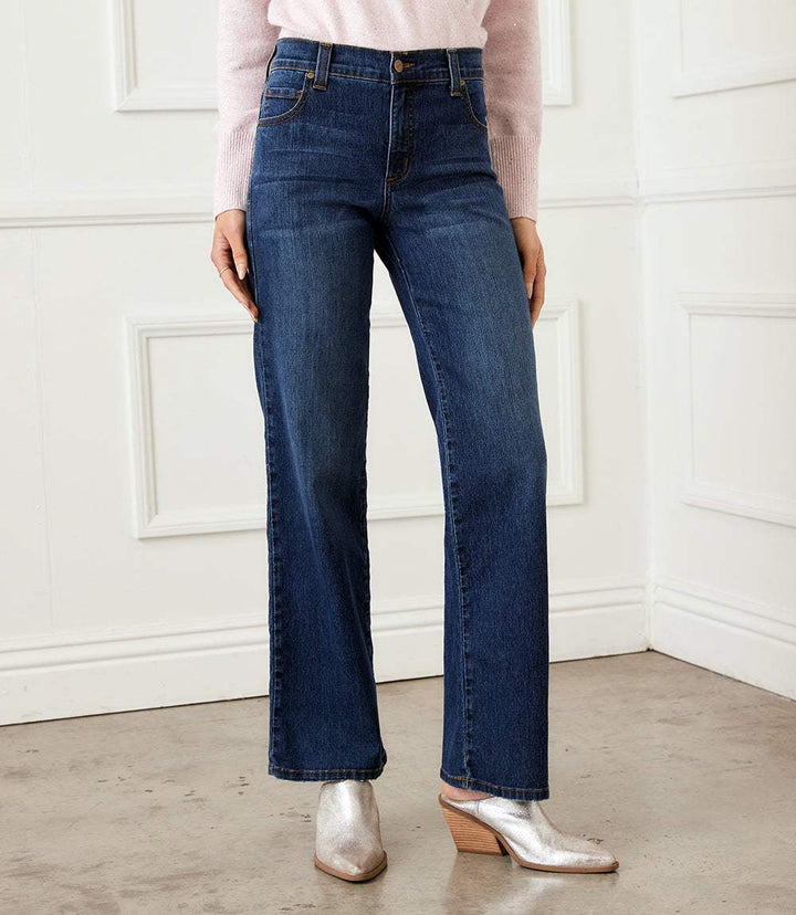 Woman wearing full length wide leg jeans in dark stretch denim with zipper closure