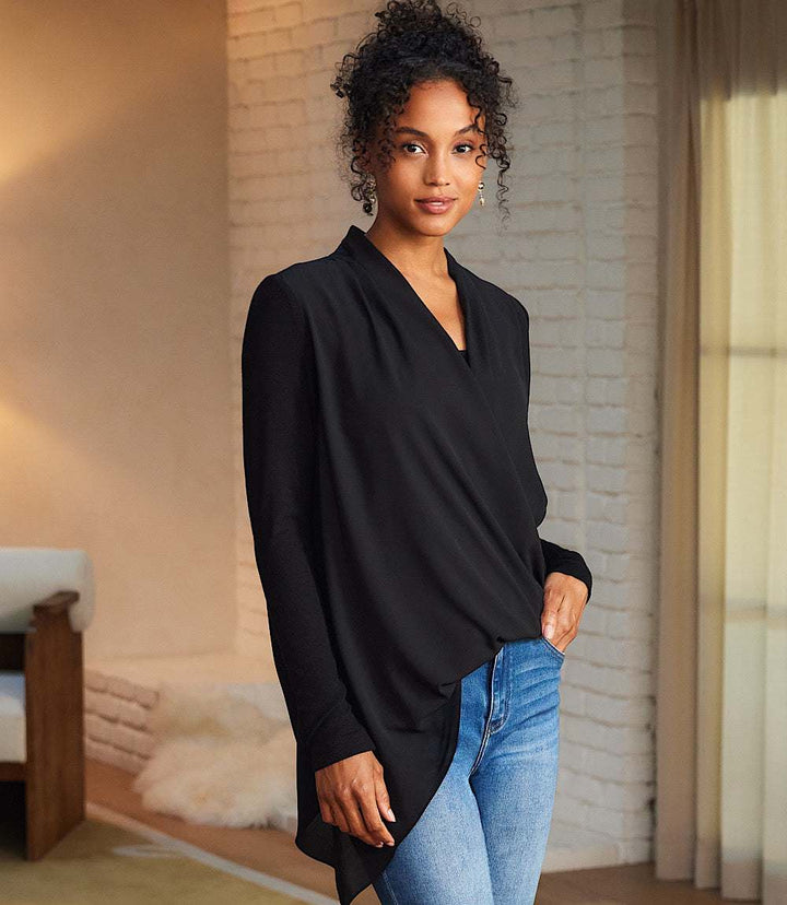 Woman wearing black Contrast Double Layer Wrap Top with crossover v-neck and asymmetrical hem paired with blue jeans