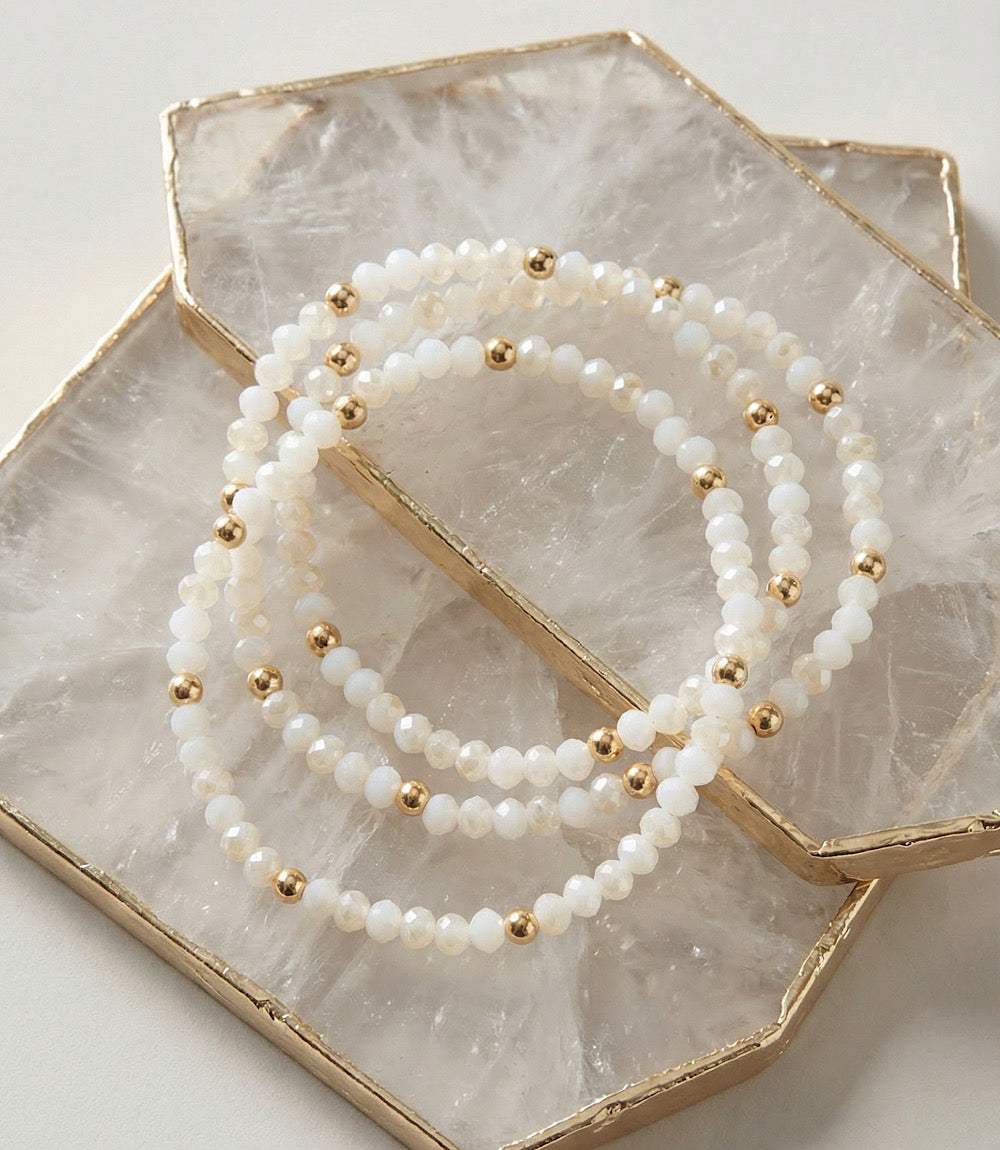 Set of 3 beaded crystal bracelets with white glass beads and gold accents, perfect for layering or individual wear