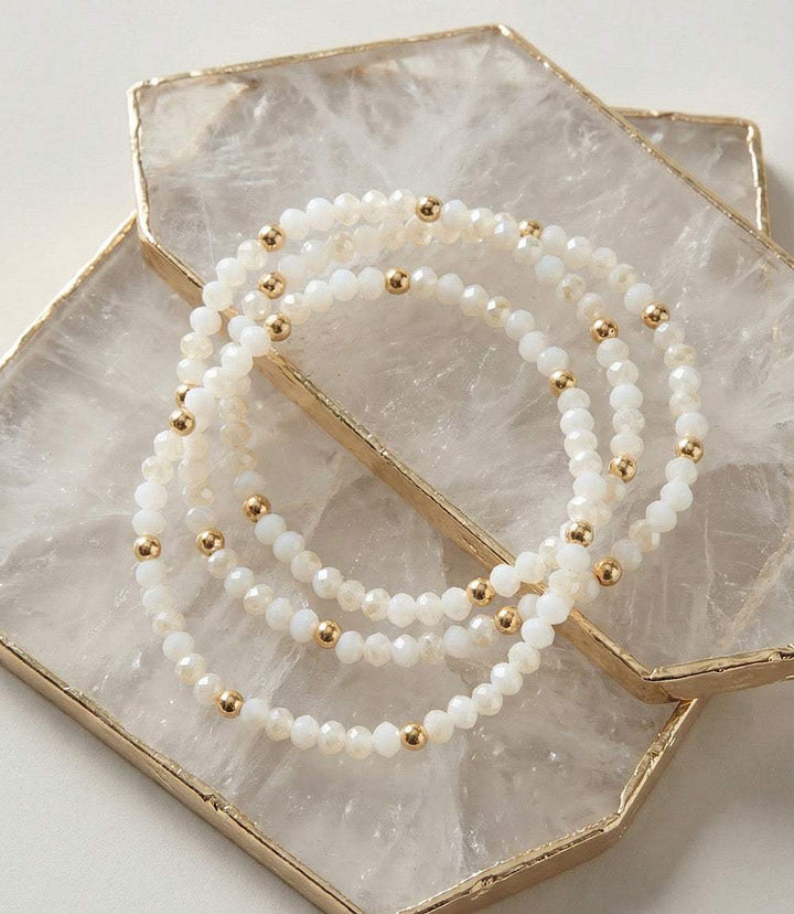 Set of 3 beaded crystal bracelets with white glass beads and gold accents, perfect for layering or individual wear