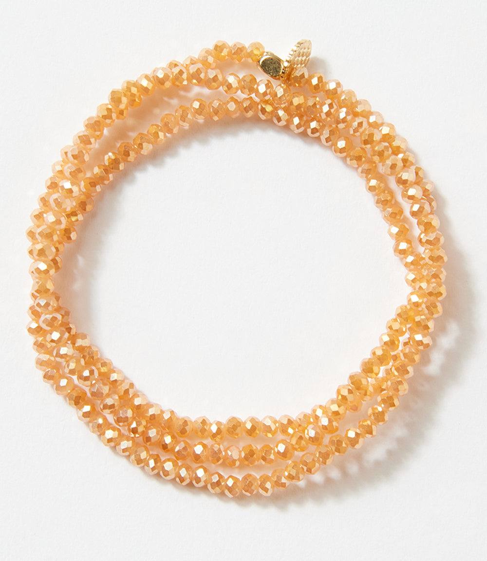 Crystal beaded stretch bracelet in a warm amber tone, wraps wrist three times, versatile as bracelet or necklace.