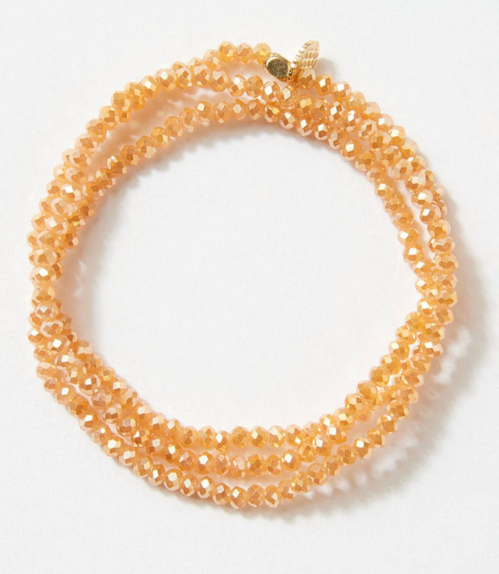 Crystal beaded stretch bracelet in a warm amber tone, wraps wrist three times, versatile as bracelet or necklace.