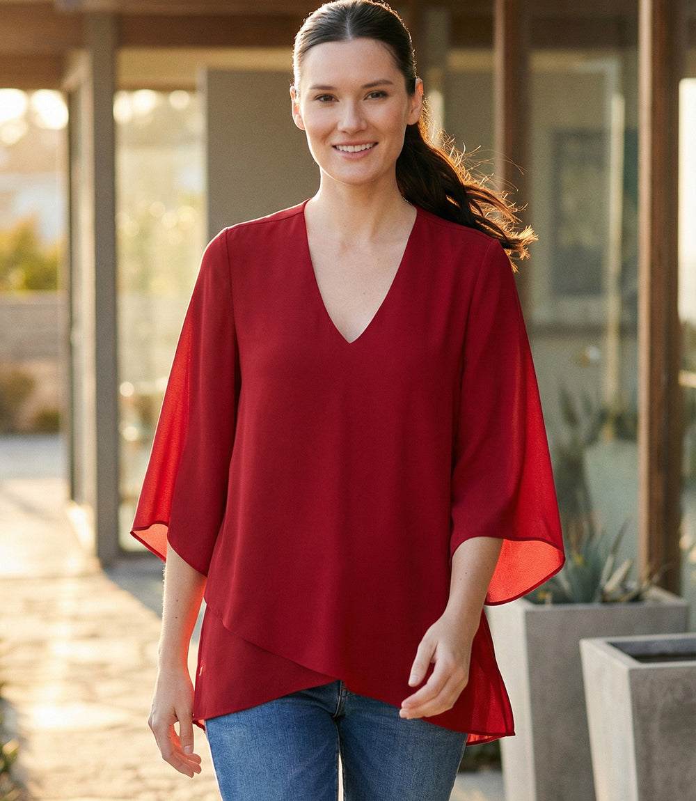 Bracelet Sleeve Asymmetric Top in silky crepe with fitted bust, flare sleeves, and layered asymmetrical hem