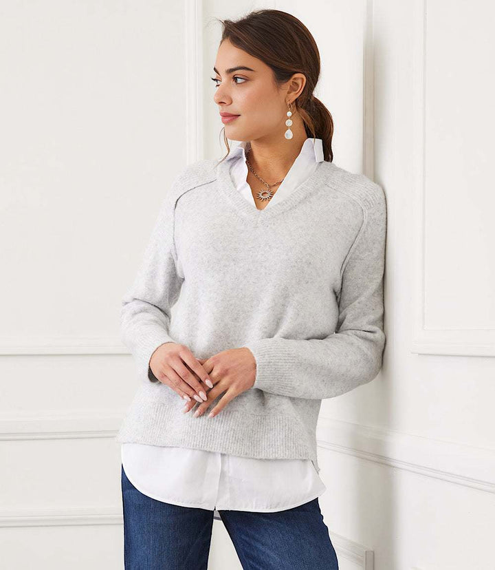 Petite size layered sweater with V-neck, shirt collar detail, raglan sleeves, and faux layered shirttail hem in light grey.