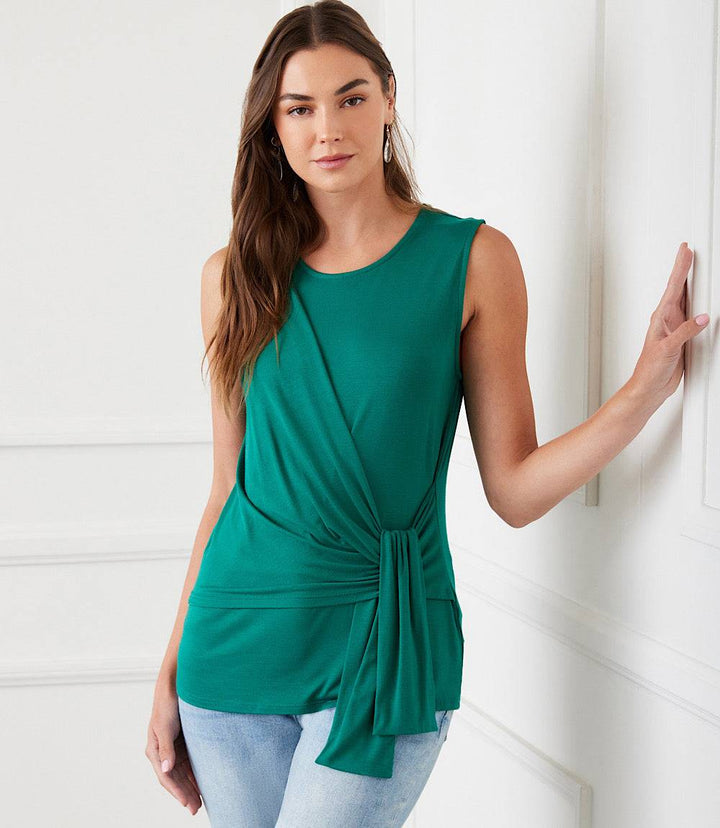 Woman wearing sleeveless green side drape top with side-tie detail and scoop neck