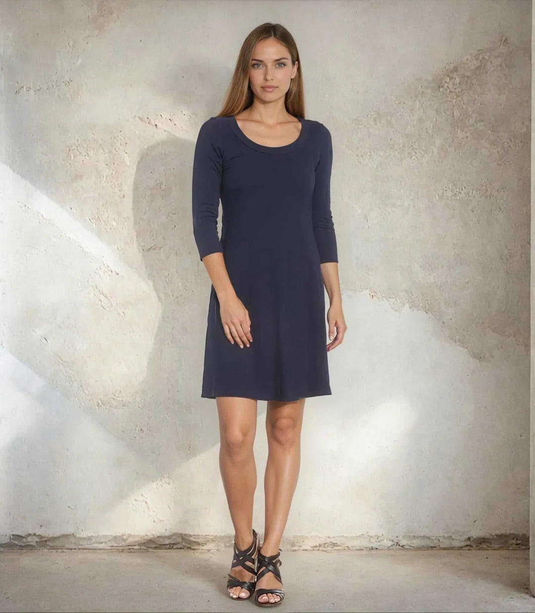 Woman wearing navy three quarter sleeve A-line dress with scoop neckline and heavy rayon spandex jersey fabric