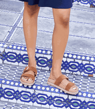Getaway Buckle Slip-On Sandals in brown leather with adjustable buckle and cushioned sole on tiled steps