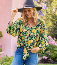 Blouson sleeve tie-front top with V-neck and golden rose print on green background