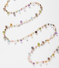Long mixed gemstone strand necklace with labradorite, peridot, aquamarine, amethyst, rose quartz, rainbow moonstone, sapphire, and gold-filled details.