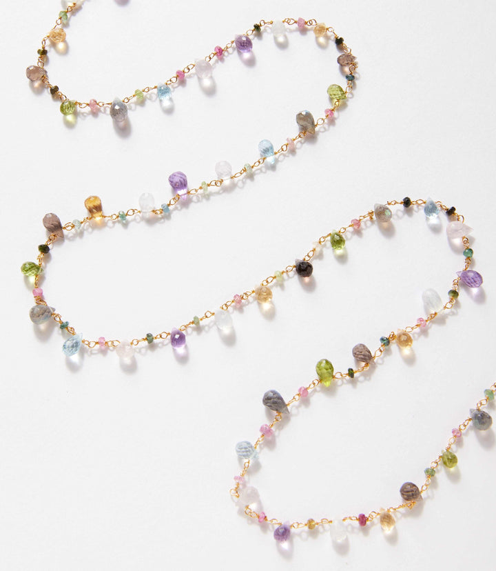 Long mixed gemstone strand necklace with labradorite, peridot, aquamarine, amethyst, rose quartz, rainbow moonstone, sapphire, and gold-filled details.
