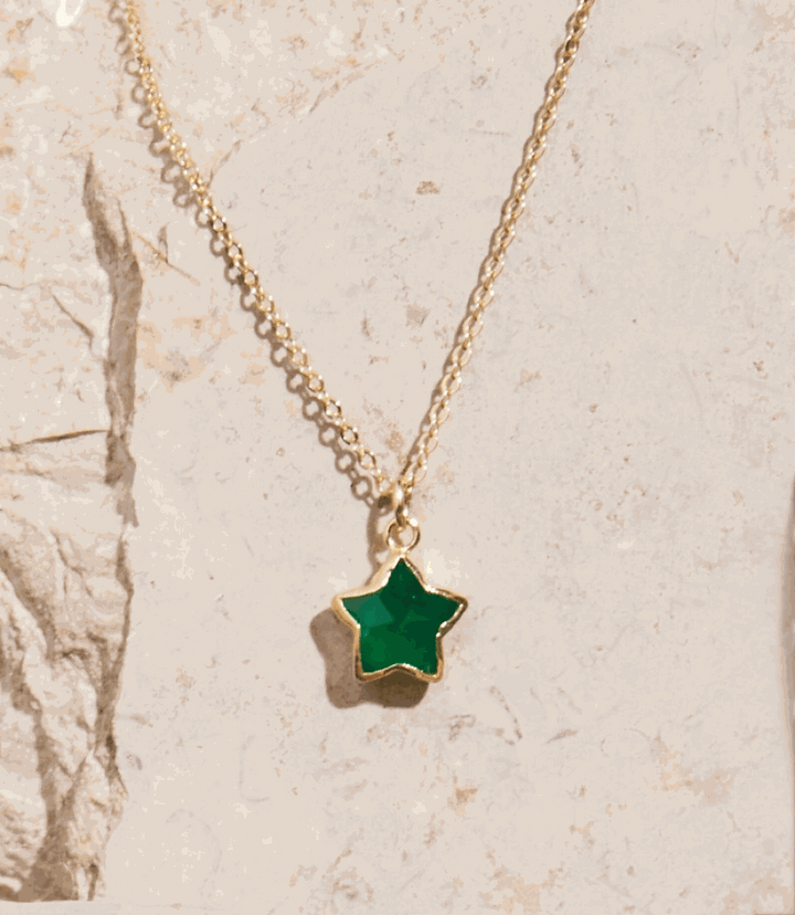 Green Onyx star-shaped pendant necklace with 14K gold filled chain on stone background