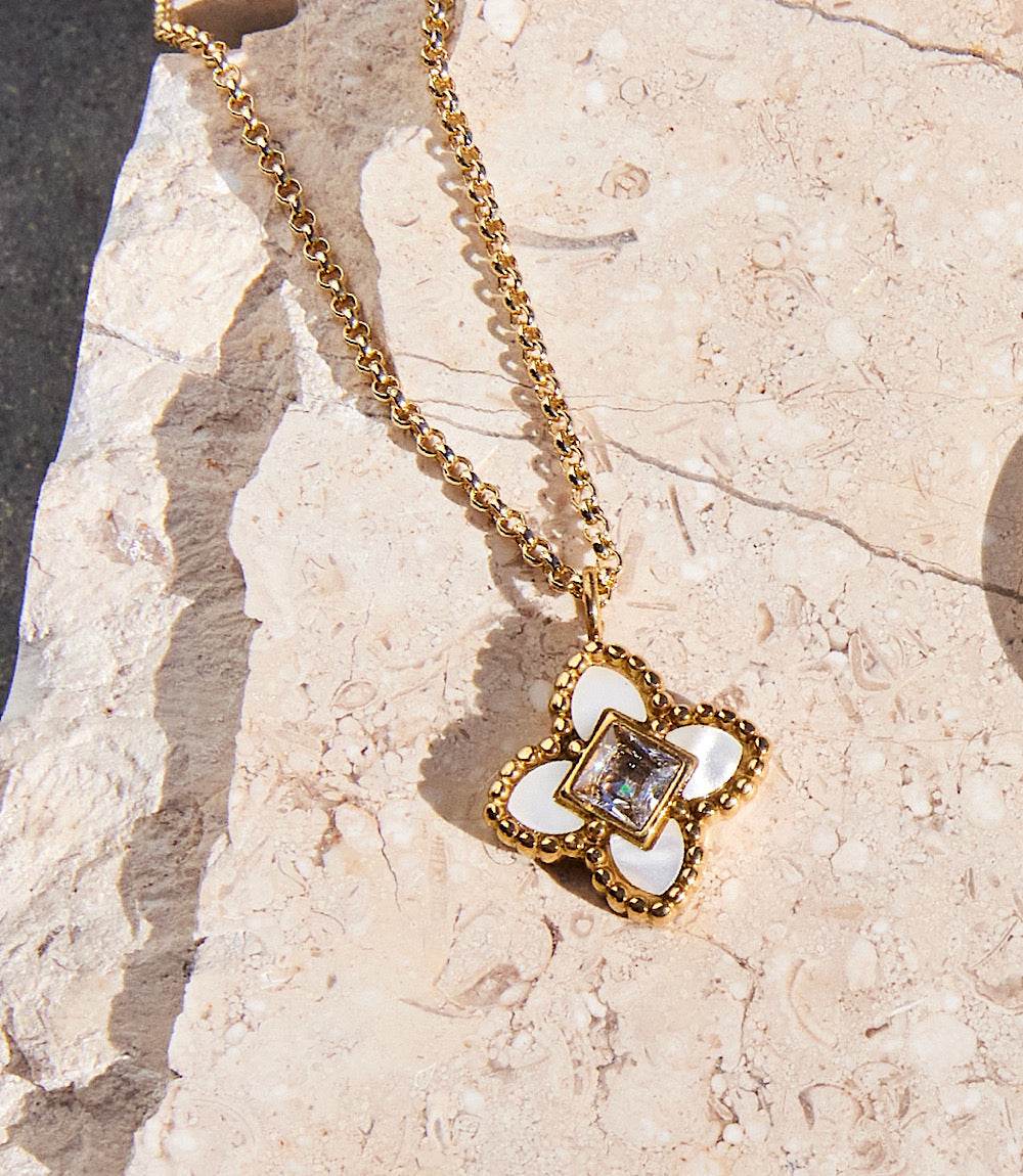 18k gold filled Diamond Lotus Necklace with white diamond lotus flower and cubic zirconia pendant on stone background