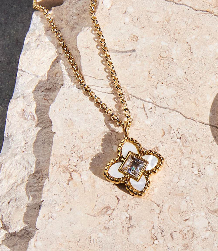 18k gold filled Diamond Lotus Necklace with white diamond lotus flower and cubic zirconia pendant on stone background