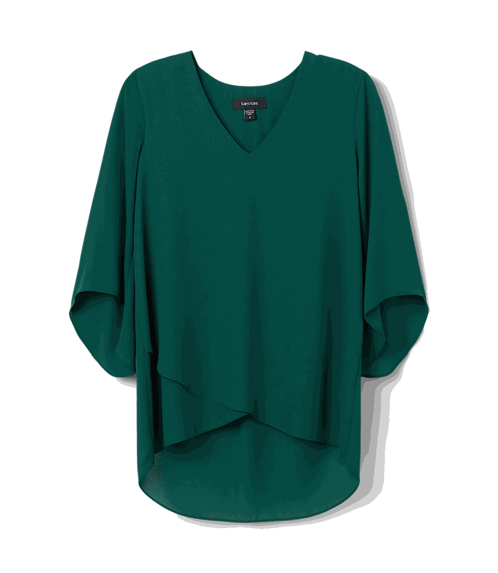 Petite asymmetric top with bracelet sleeves, silky crepe fabric, V-neck, and layered hem in dark green.