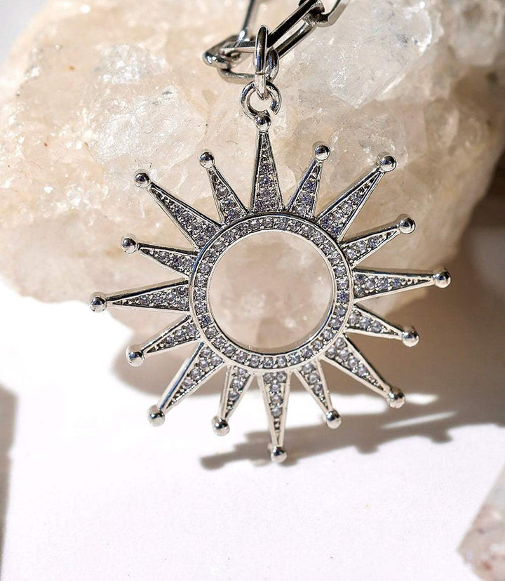 Pavé Sunburst Necklace with clear crystal sunburst pendant in plated stainless steel, 17-inch chain with extender, lightweight and elegant design.