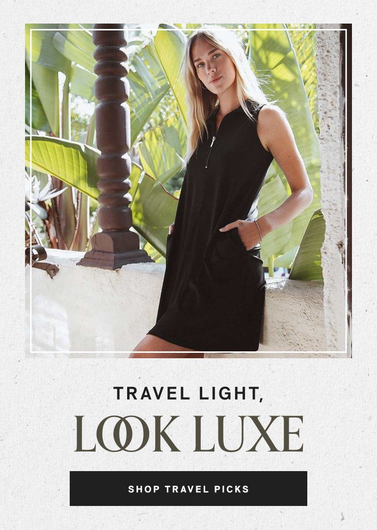 Woman in a black dress standing in front of tropical plants with 'Travel Light, Look Luxe' text.