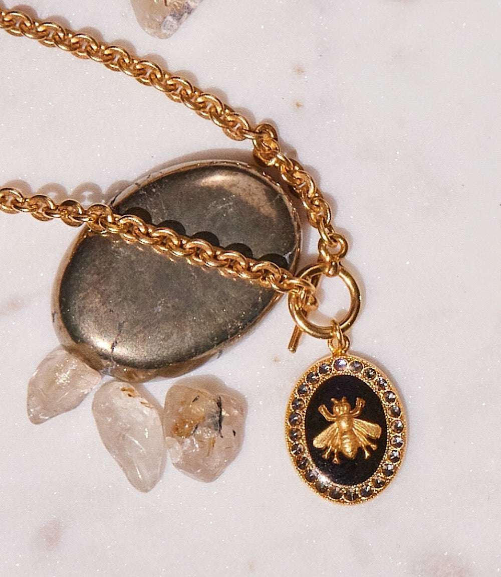 Crystal Bee Charm Bracelet with gold bee pendant, black background, and Swarovski crystals on gold chain