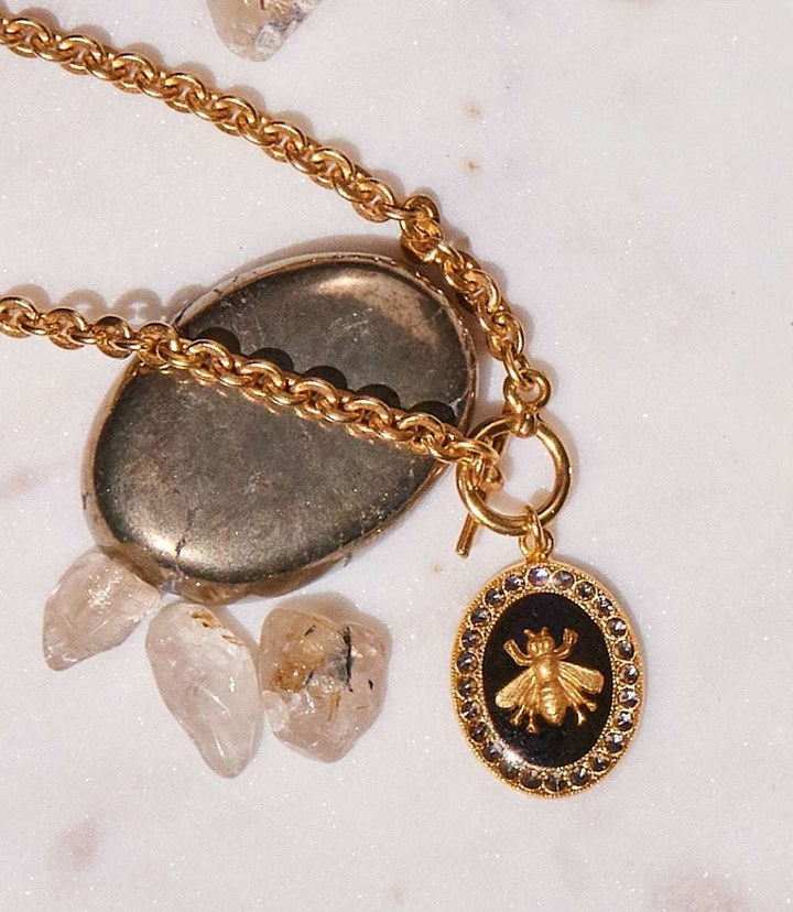 Crystal Bee Charm Bracelet with gold bee pendant, black background, and Swarovski crystals on gold chain