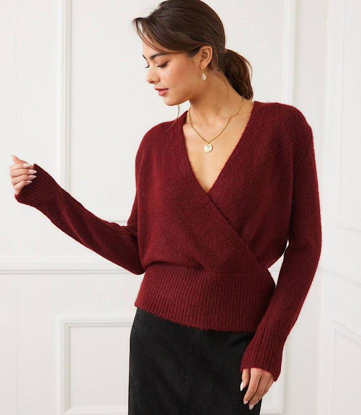 Woman wearing a burgundy petite size wrap sweater with deep V-neck and ribbed hem