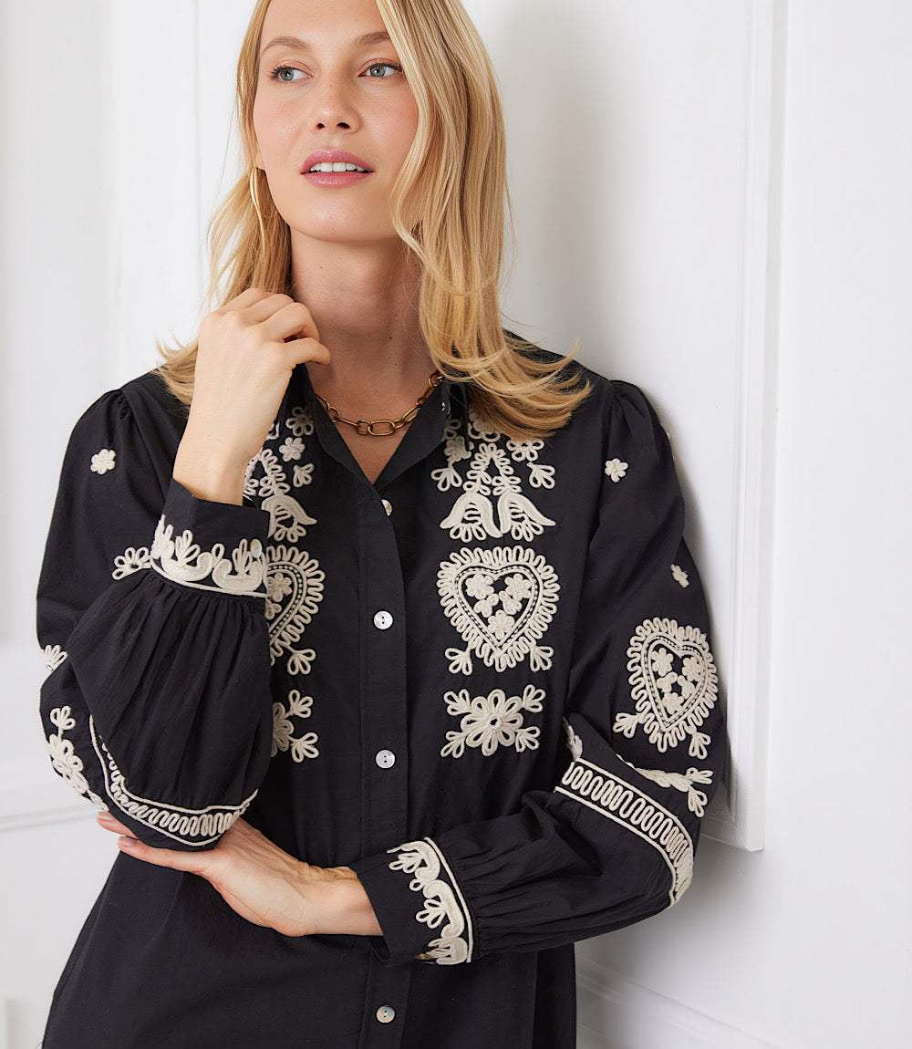 Black shirtdress with cream rope-stitch embroidery and blouson sleeves with embroidered cuffs