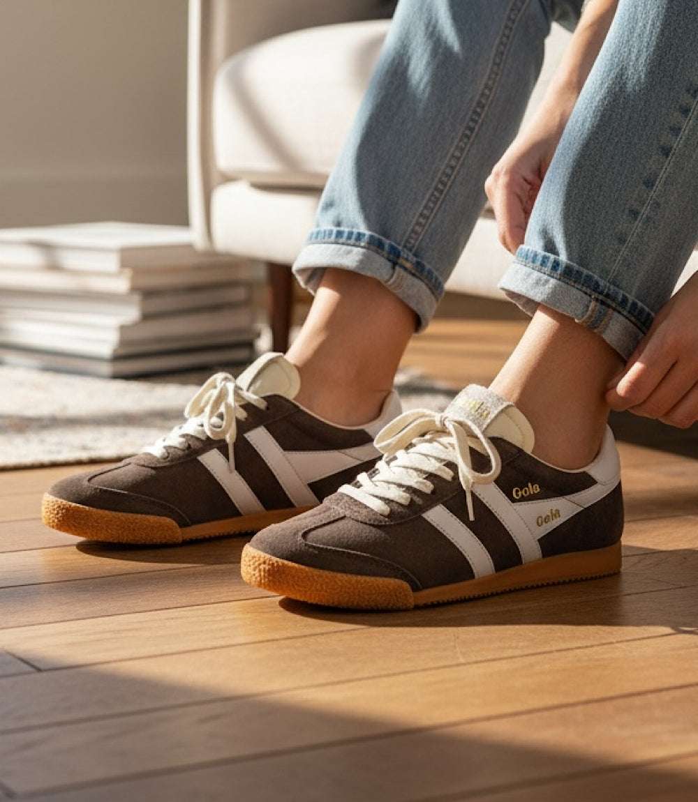 Gola Elan Classic Sneakers in mocha suede with white stripes and gum sole worn with jeans indoors