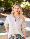 Woman wearing a light-colored shirt with a blurred natural background