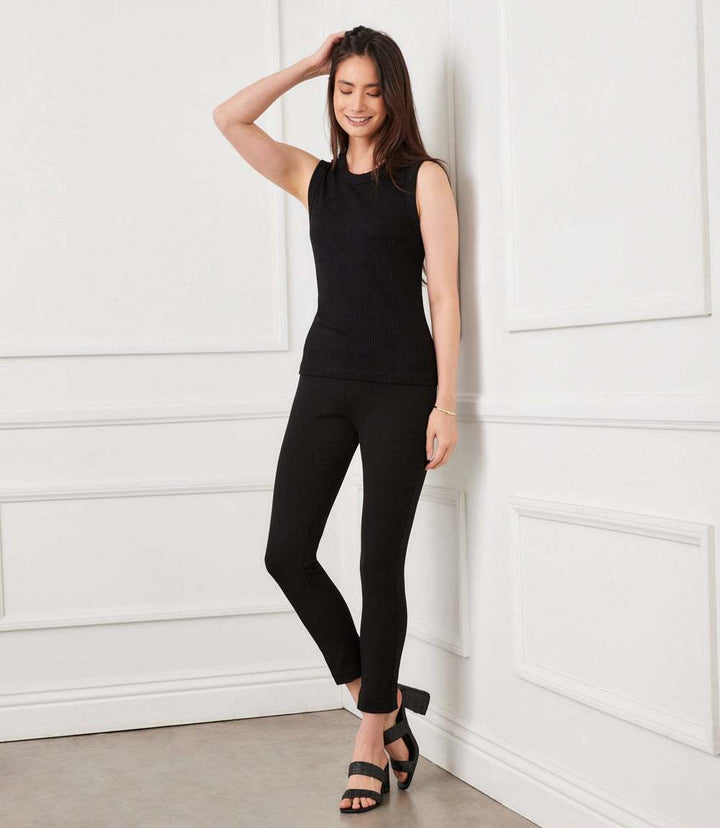 Woman wearing black skinny ankle-length Piper Pants with double stretch fabric and sleeveless top