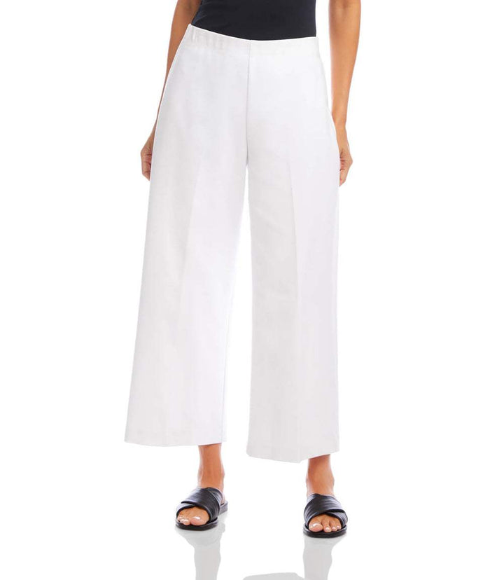 Woman wearing white cropped wide-leg pants with elastic waistband and no pockets, paired with black top and slide sandals