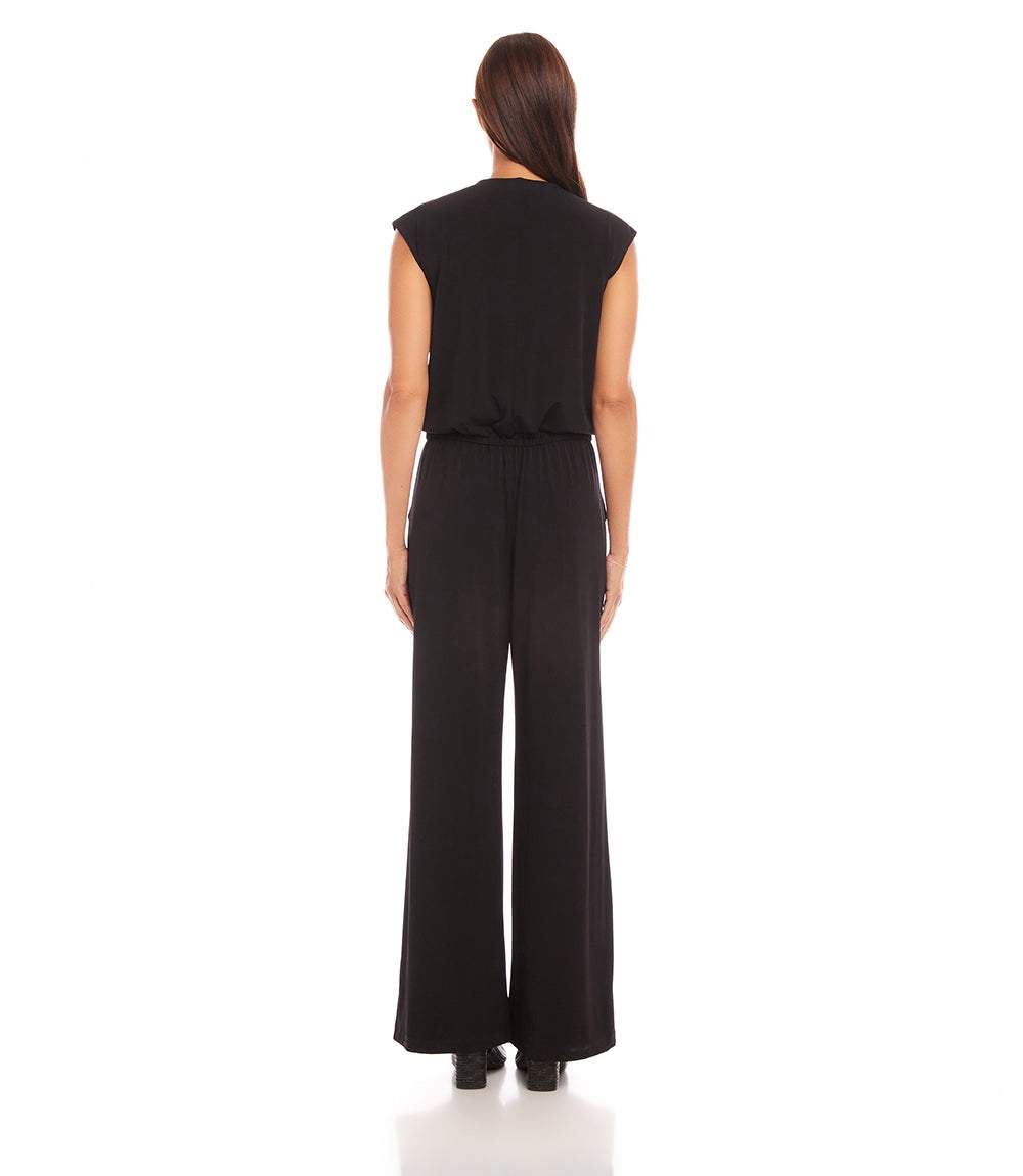 Back view of a petite size sleeveless black travel jersey jumpsuit with wide-leg pants and elastic waistband.