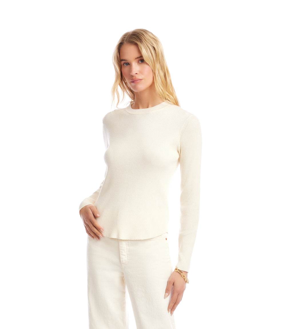 Woman wearing a fitted white ribbed crewneck sweater with long sleeves and a clean silhouette.