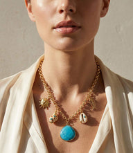 Turquoise Sea Charm Necklace with gold-plated chain and seashell charm on white background