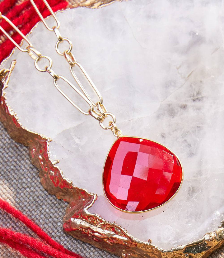 Ruby quartz pendant necklace with faceted red stone and gold-plated elongated-link chain