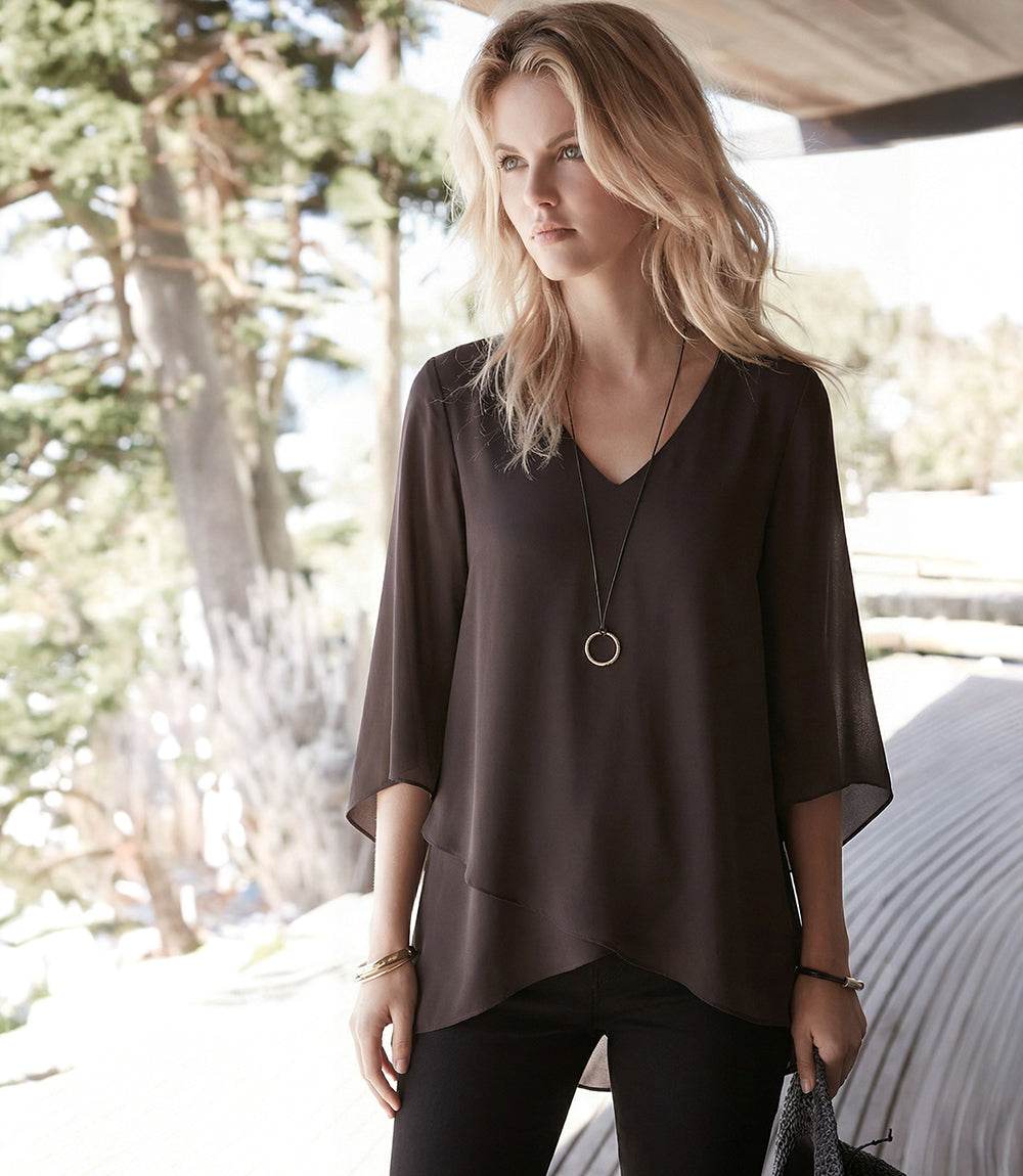 Bracelet Sleeve Asymmetric Top in silky crepe with V-neck, flare sleeves, and layered asymmetrical hem