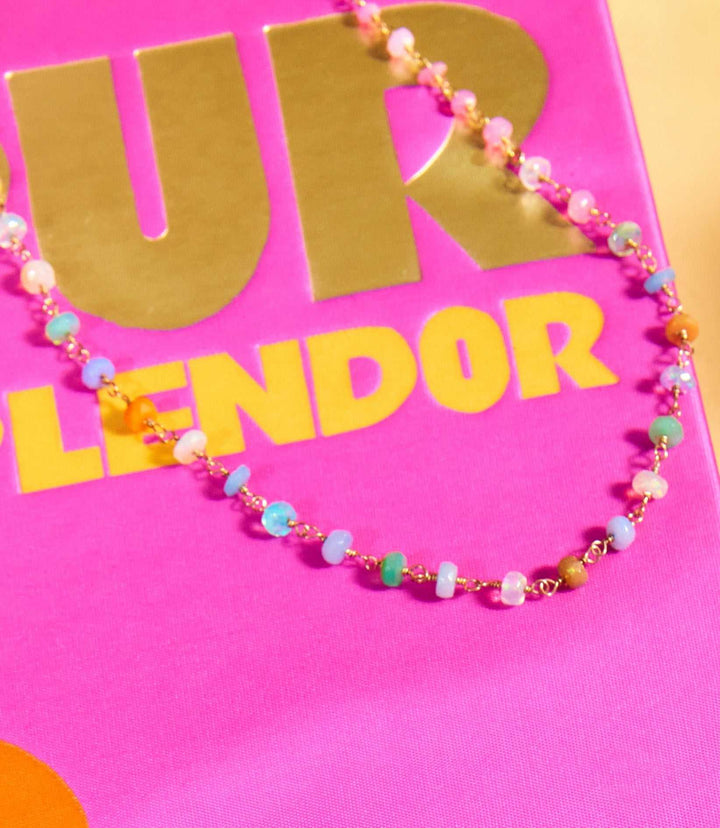 Neon beaded gemstone necklace with colorful opal beads and 14k gold fill chain on pink background
